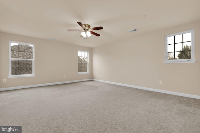 empty room featuring ceiling fan and light colored carpet