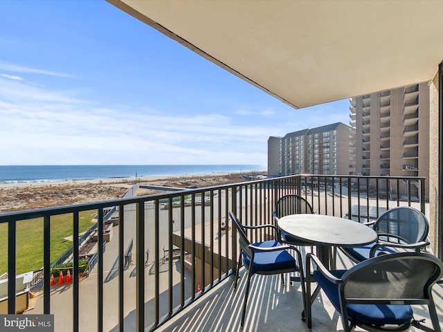 balcony featuring a beach view and a water view