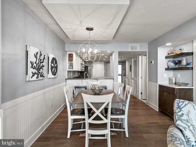 dining area featuring dark hardwood / wood-style floors, sink, and a notable chandelier