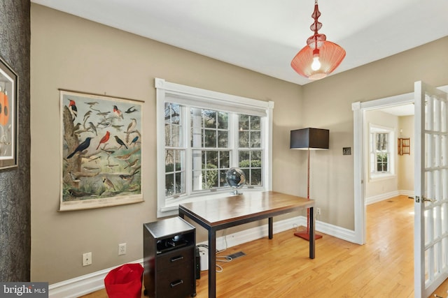 dining space with light wood finished floors, visible vents, and baseboards