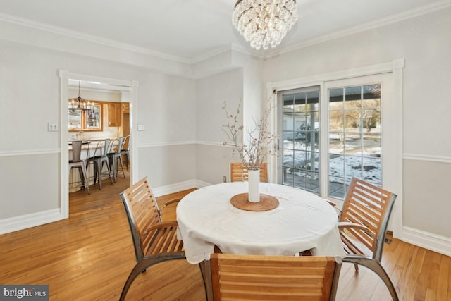 dining space with a chandelier, light wood finished floors, and baseboards