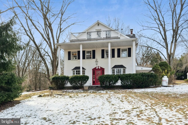 greek revival inspired property featuring a chimney and a balcony