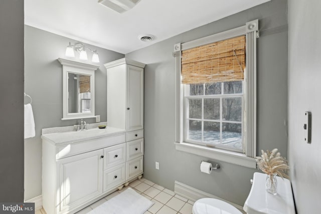 half bath with toilet, tile patterned flooring, vanity, and visible vents