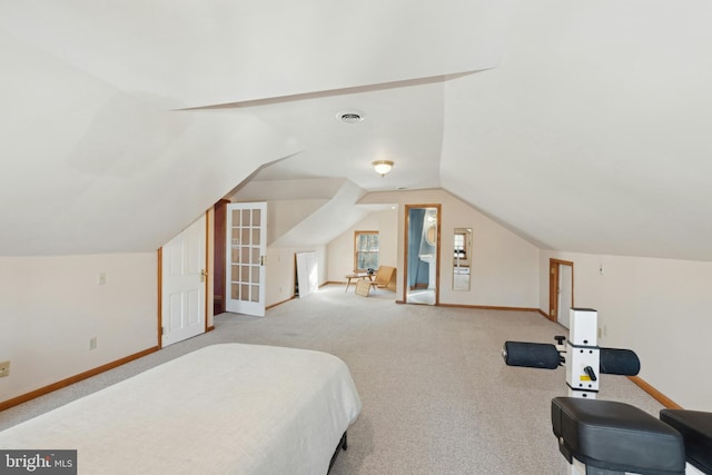 bedroom with vaulted ceiling, carpet flooring, visible vents, and baseboards