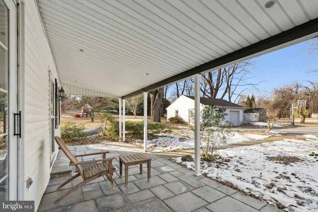 snow covered patio featuring a garage