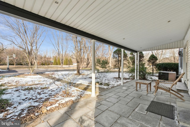 snow covered patio featuring central AC unit