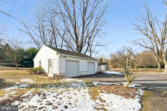 snow covered garage with a garage