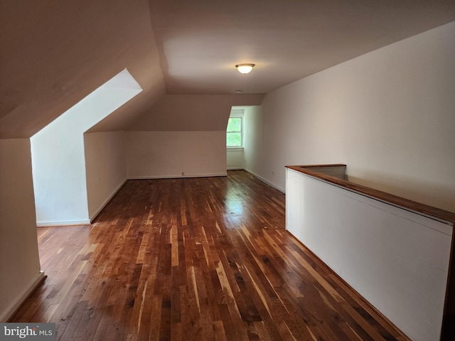 bonus room featuring dark wood-type flooring and vaulted ceiling