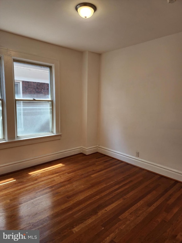 spare room with dark wood-type flooring