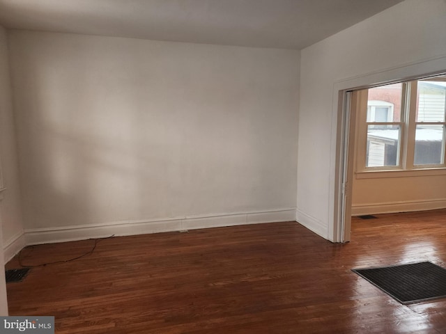 unfurnished room featuring dark wood-type flooring