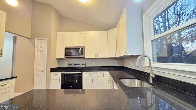 kitchen with white cabinetry, range with electric stovetop, sink, vaulted ceiling, and dark stone countertops