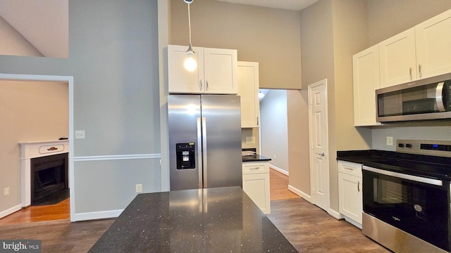 kitchen with white cabinetry, hanging light fixtures, and stainless steel appliances