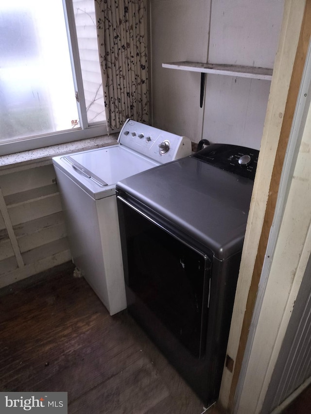 washroom with washing machine and clothes dryer and dark hardwood / wood-style flooring