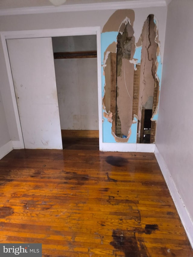 unfurnished bedroom featuring dark hardwood / wood-style flooring and a closet