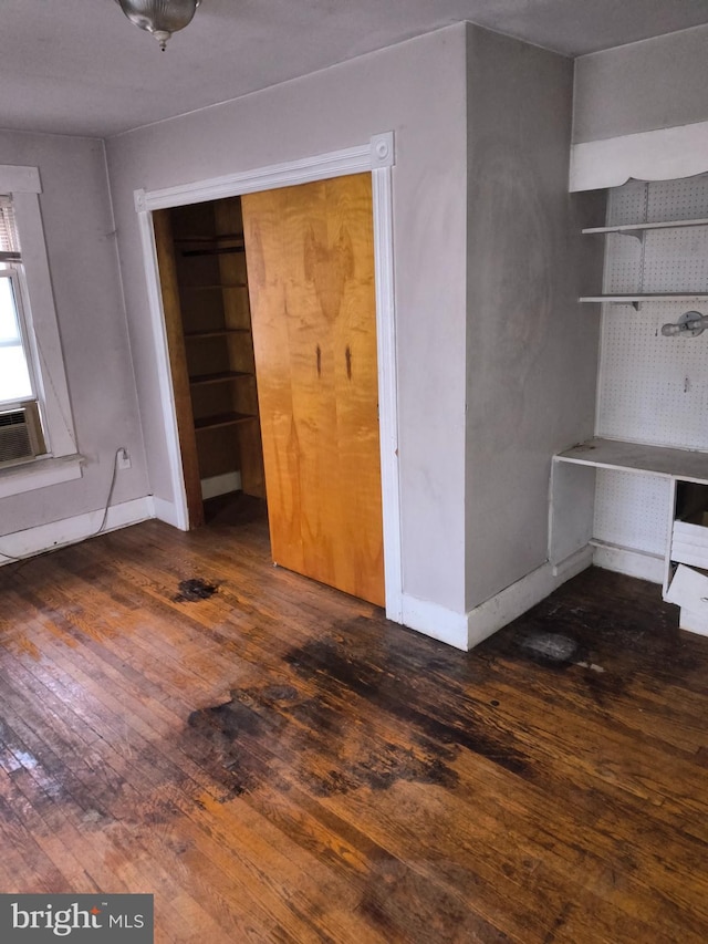 unfurnished bedroom featuring dark wood-type flooring and a closet