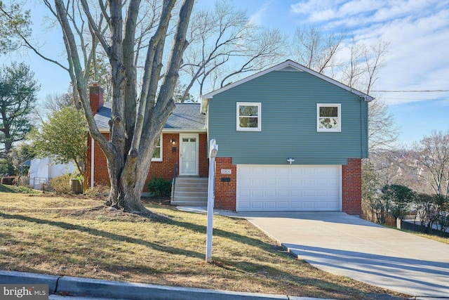 tri-level home featuring a garage and a front lawn