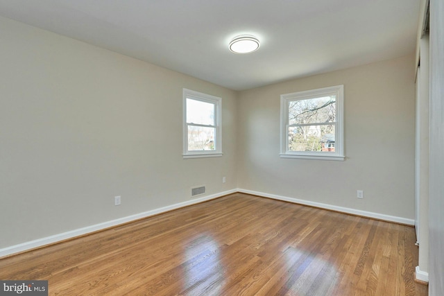 spare room featuring light hardwood / wood-style flooring and plenty of natural light