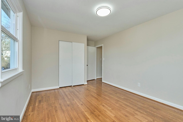 unfurnished bedroom featuring a closet and light wood-type flooring