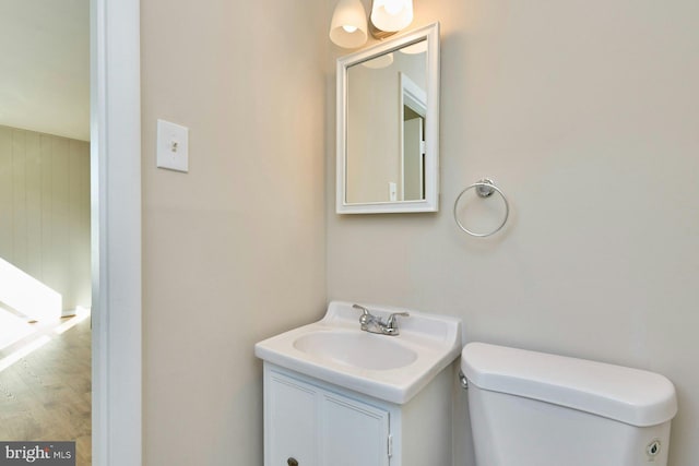 bathroom featuring vanity, hardwood / wood-style flooring, and toilet