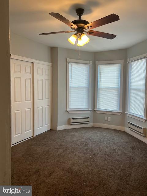 interior space with a baseboard radiator and a wall unit AC