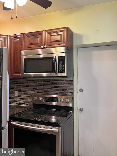 kitchen with decorative backsplash, stainless steel appliances, and ceiling fan