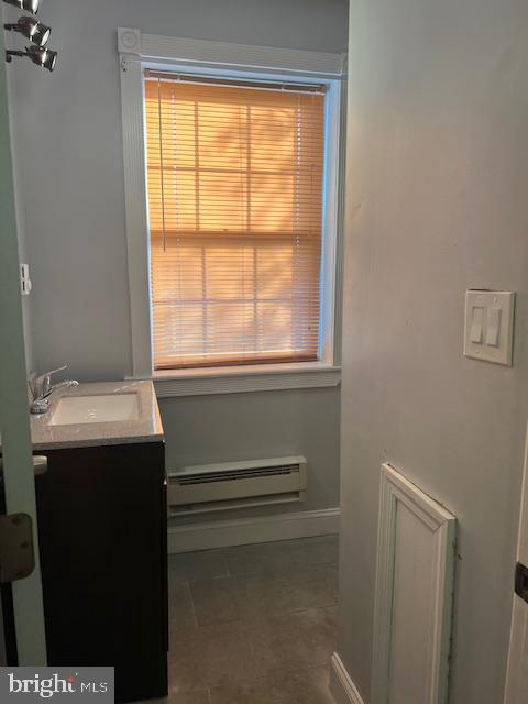 bathroom featuring a baseboard radiator, a healthy amount of sunlight, and vanity