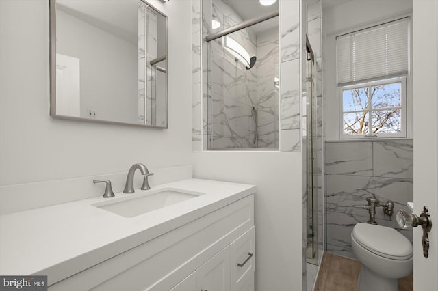 bathroom featuring vanity, a shower with shower door, and toilet