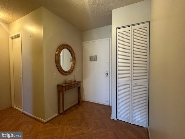 hallway with a textured ceiling and baseboards