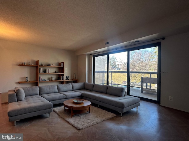 living area featuring visible vents and a textured ceiling