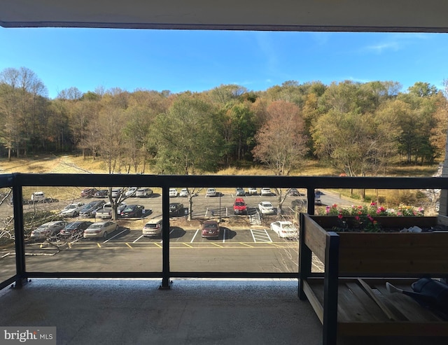 balcony featuring a forest view