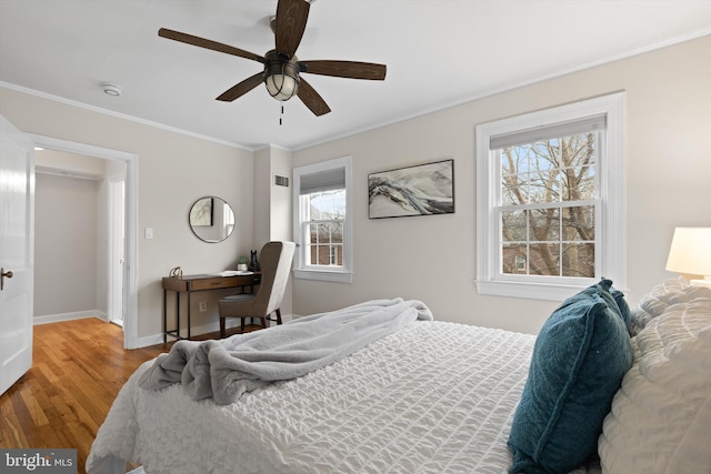 bedroom with crown molding, ceiling fan, and hardwood / wood-style flooring