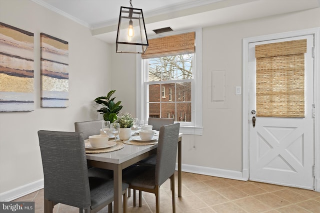 dining space with crown molding and tile patterned floors