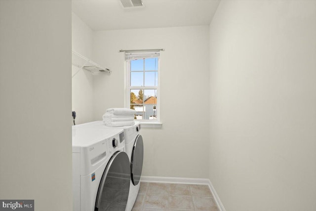 washroom featuring washing machine and clothes dryer and light tile patterned floors