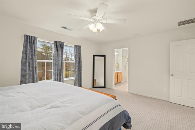 bedroom with light colored carpet, ceiling fan, and ensuite bathroom