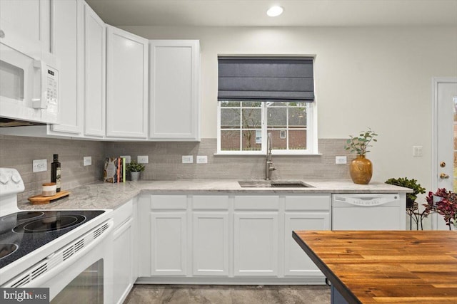 kitchen featuring white cabinetry, sink, white appliances, and backsplash