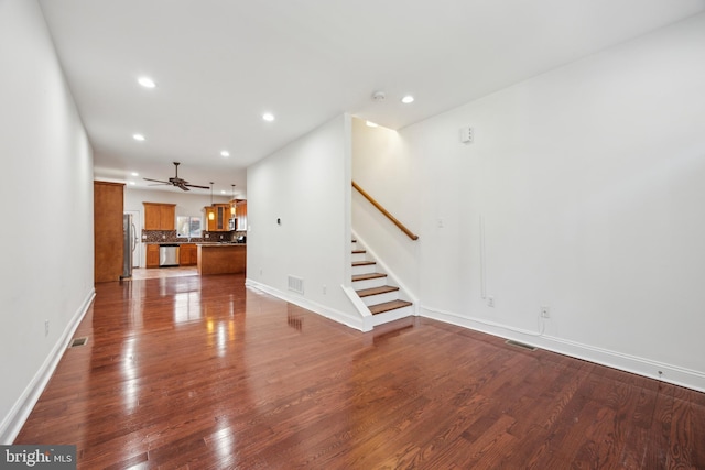 unfurnished living room with dark wood-type flooring and ceiling fan