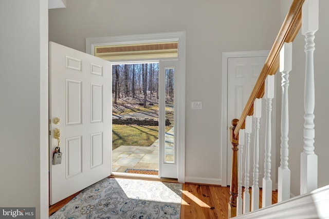 entryway featuring stairway, wood finished floors, and baseboards