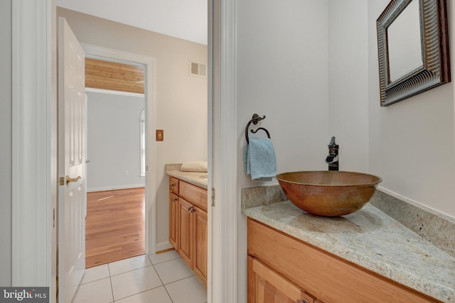 bathroom featuring tile patterned flooring, vanity, visible vents, and baseboards