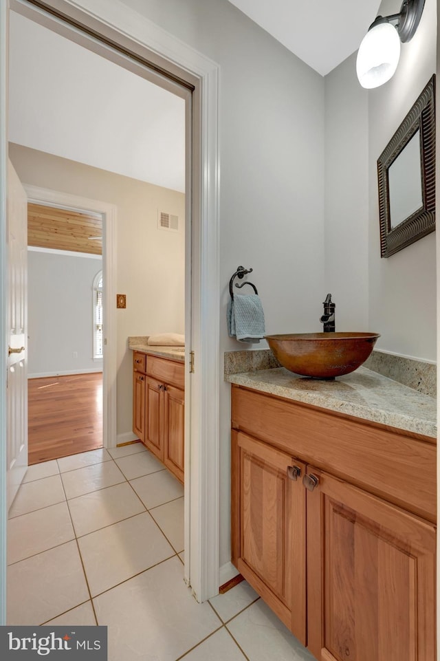 bathroom featuring baseboards, vanity, visible vents, and tile patterned floors