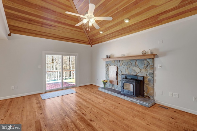 unfurnished living room featuring baseboards, lofted ceiling, wooden ceiling, wood finished floors, and a wood stove