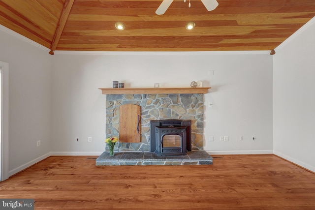 unfurnished living room with baseboards, wood ceiling, ornamental molding, wood finished floors, and a wood stove