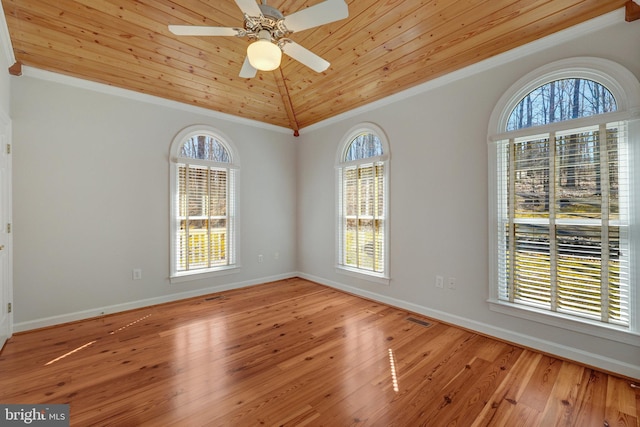 unfurnished room featuring baseboards, visible vents, wooden ceiling, wood finished floors, and vaulted ceiling