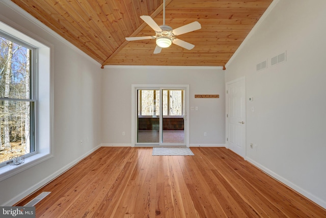 spare room featuring light wood-type flooring, visible vents, and baseboards