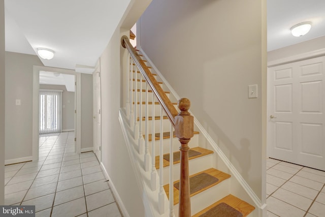 stairs featuring baseboards and tile patterned floors