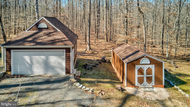 detached garage featuring a view of trees