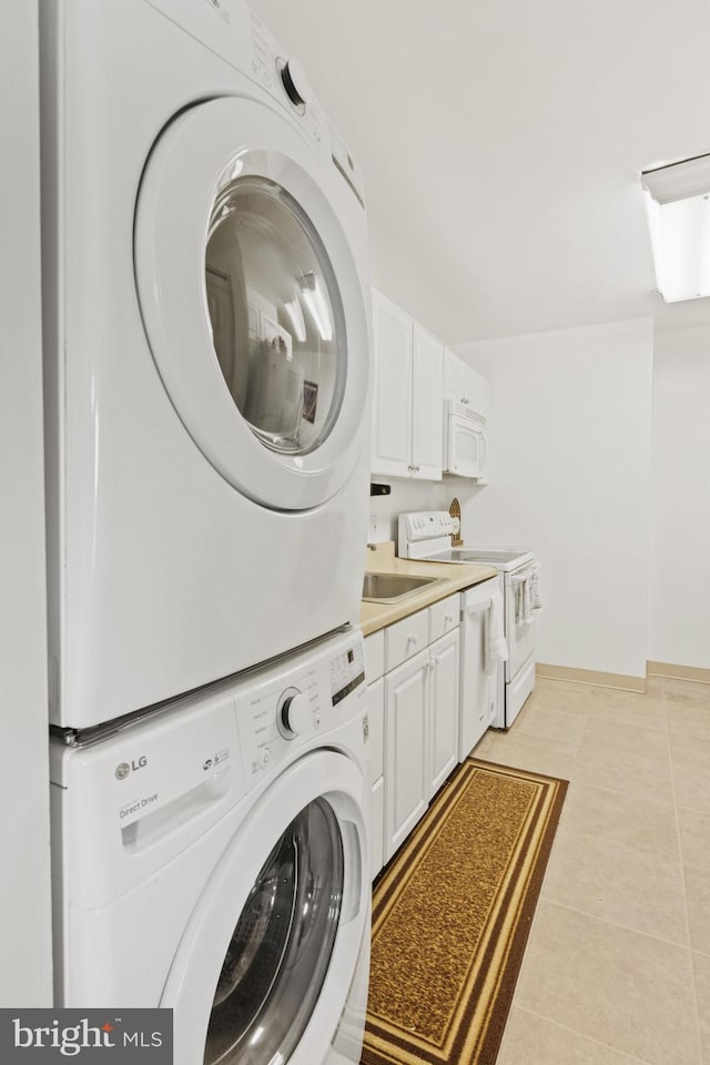 laundry area with stacked washer / drying machine, sink, and light tile patterned floors