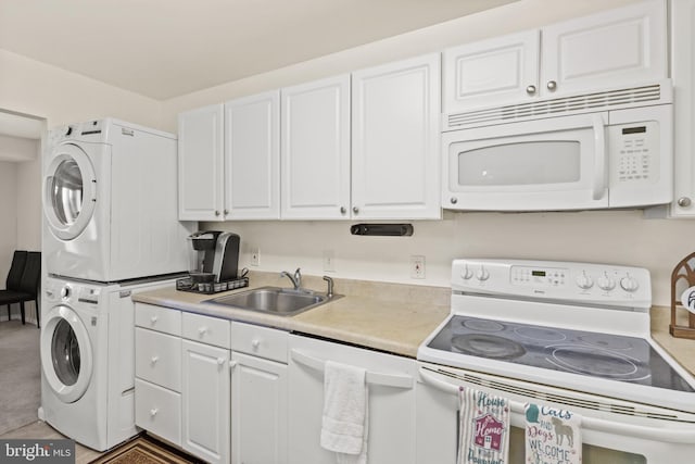 kitchen with white cabinetry, white appliances, stacked washer and clothes dryer, and sink