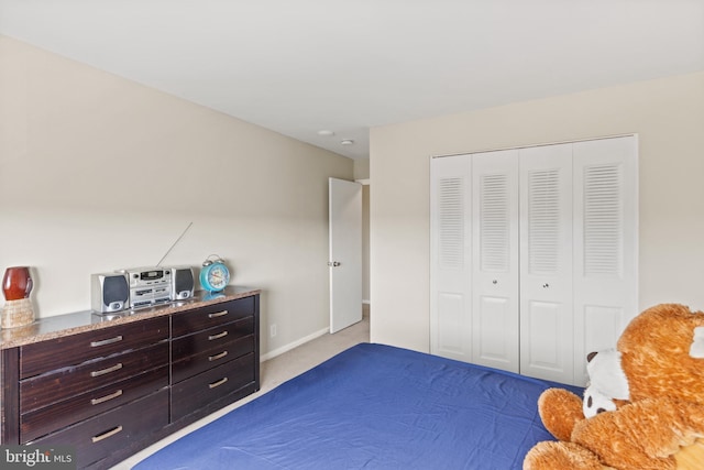 bedroom featuring light colored carpet and a closet