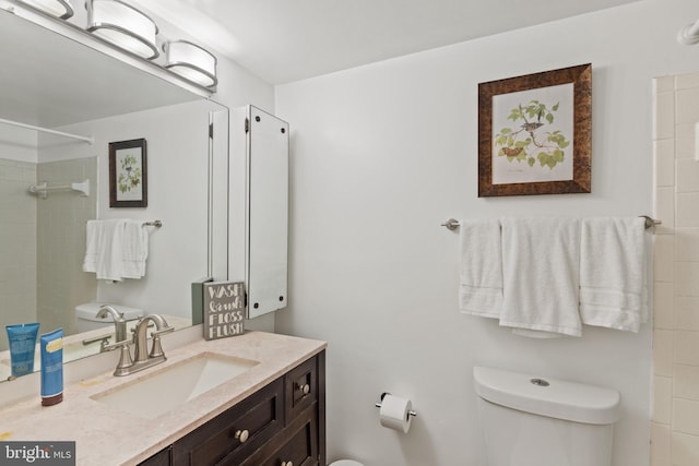 bathroom with vanity, toilet, and a tile shower