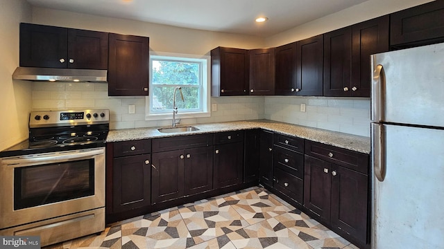 kitchen with dark brown cabinetry, sink, light stone counters, stainless steel electric range oven, and refrigerator